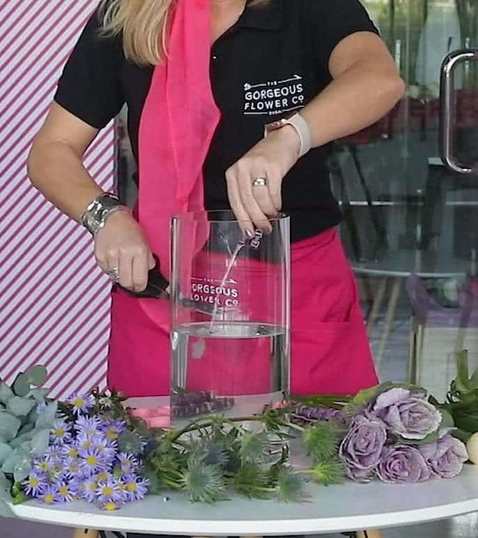 Sam demonstrating how to cut the stems and prepare your bouquet in a vase