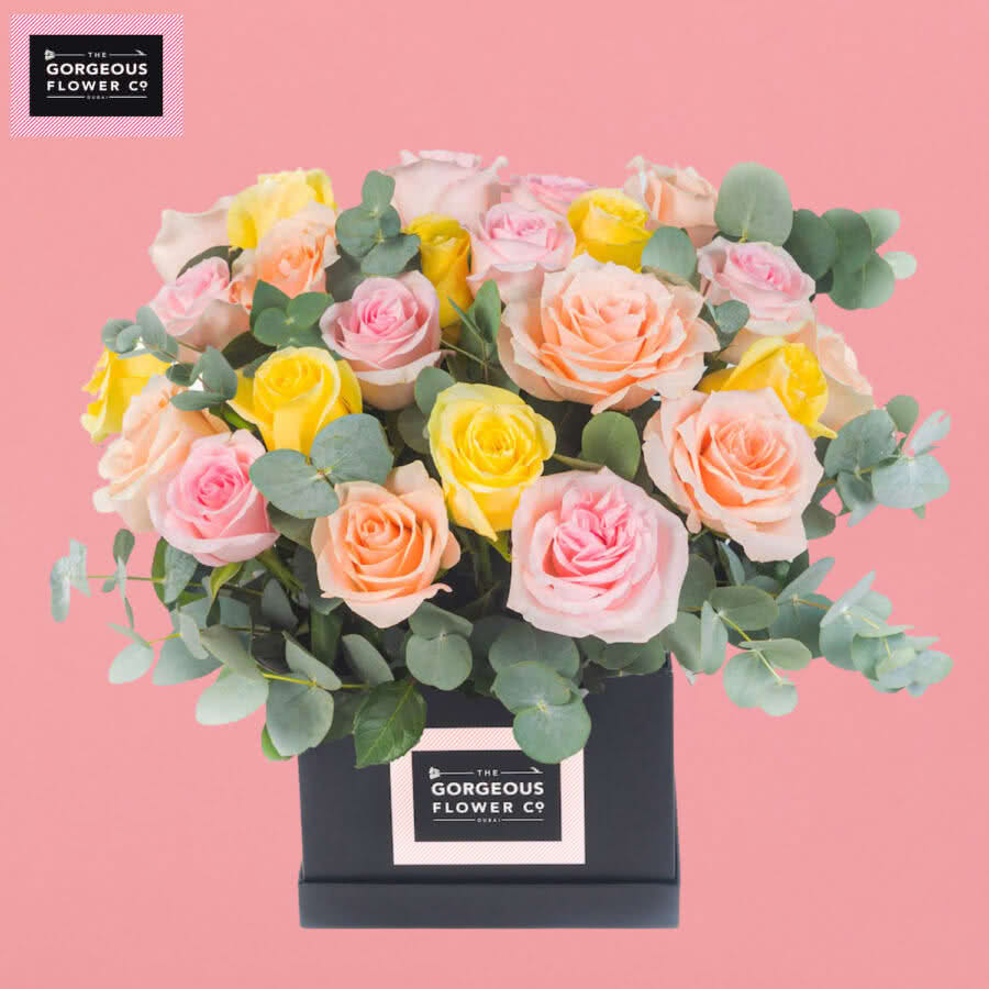 Palm Cove Arrangement with Peach, Pink and Yellow Roses.